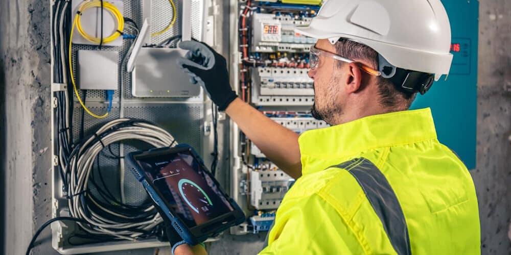 man-electrical-technician-working-switchboard-with-fuses-uses-tablet (Freepik)